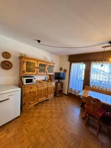 a kitchen with wooden cabinets and a white refrigerator at Pragma Apartments - Cupido's Alpine Nest in Bellamonte