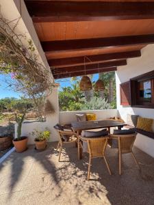 a patio with a wooden table and chairs at Michel Dos apartamentos in San Ferrán de ses Roques
