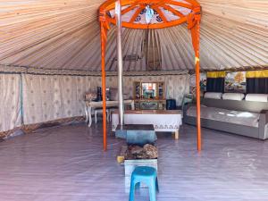 a room with a tent with a bed and a chair at Mongolian Nomadic Herders in Dörgön