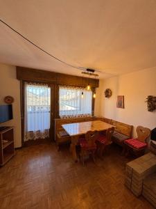 a living room with a wooden table and chairs at Pragma Apartments - Cupido's Alpine Nest in Bellamonte +9 photos