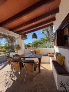 an outdoor patio with a wooden table and chairs at Michel Dos apartamentos in San Ferrán de ses Roques