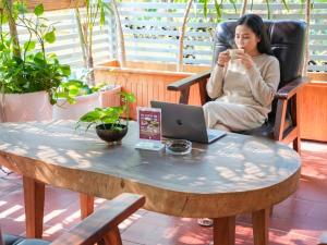 a woman sitting in a chair at a table with a laptop at Le Kree Downtown Hotel in Phnom Penh +71 photos