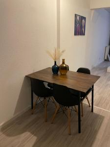 a wooden table with a vase and two chairs at Sand Home in Le Puy-en-Velay +8 photos