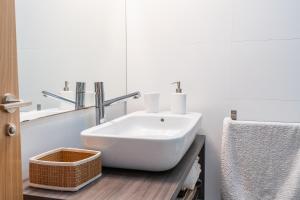 a bathroom with a white sink and a mirror at Apartamento Serenity in Cunit +18 photos