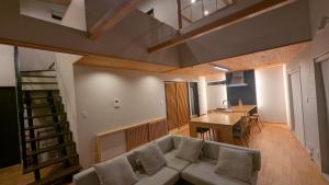 a living room with a couch and a dining room at Namioto Villa YOSA in Hama