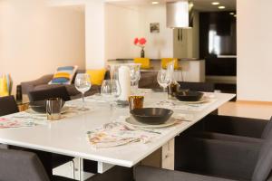 una mesa blanca con copas de vino y platos en ella en Apartamento Vista Mar, en Olhão