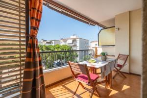 a balcony with a table and chairs and a window at Apartamento Serenity in Cunit