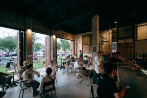 a group of people sitting at tables in a restaurant at Kosin House in Bangkok +53 photos