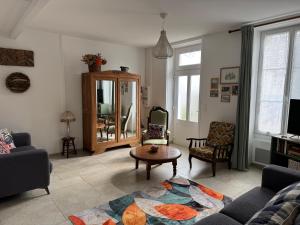 a living room with a couch and a table at ancienne ferme maison familiale in Chaucre