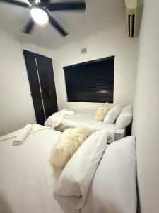 a room with three beds with white pillows at SeaBreeze Sanctuary in Richards Bay