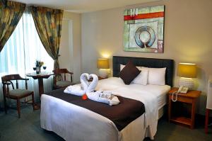 two swans sitting on a bed in a hotel room at Casona Plaza Hotel Puno in Puno