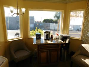 een keuken met twee ramen en een aanrecht en twee stoelen bij Continental Lodge in Oakland