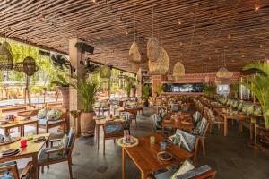a restaurant with wooden ceilings and tables and chairs at Café del Mar Phuket - Suite & Penthouse in Kamala Beach