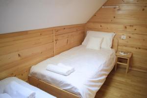 a twin bed in a room with wooden walls at Chalet Pokljuka in Goreljek
