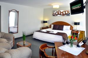 een hotelkamer met een bed en een tafel en stoelen bij Casona Plaza Hotel Puno in Puno