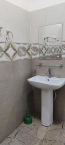 a bathroom with a white sink and a mirror at Calm Night Surf Stay in Arugam Bay