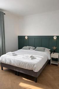 a large bed in a bedroom with a green headboard at Le Thuillat Limoges in Limoges