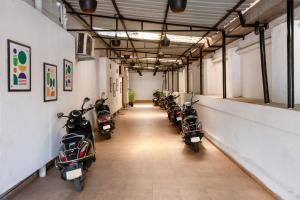 a row of motorcycles parked in a long hallway at Treebo Royal Empire in Chinchwad +27 photos