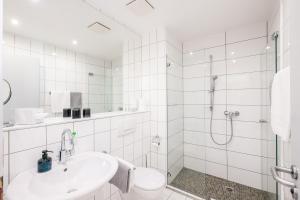 a white bathroom with a shower and a sink at Inselhotel Rügen in Göhren +101 photos