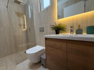 a bathroom with a toilet and a sink and a shower at Loris Rooms in Yrshek