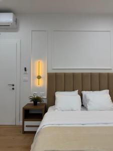 a bedroom with a bed with white sheets and a table at Loris Rooms in Yrshek +7 photos