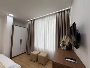a bedroom with a bed and a television on a table at Loris Rooms in Yrshek