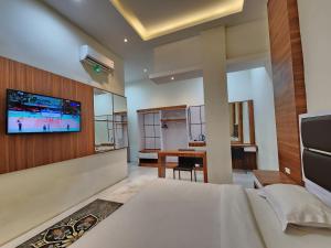 a bedroom with a bed and a tv on a wall at hotel diana in Banda Aceh