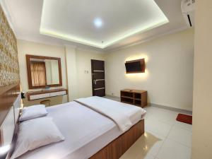 a bedroom with a large bed and a sink at hotel diana in Banda Aceh