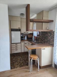 a kitchen with a table and two stools in it at Leissi2025 in Leissigen