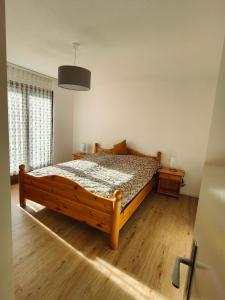 a bedroom with a wooden bed and a window at Leissi2025 in Leissigen