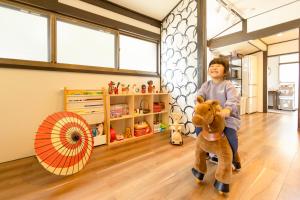 a young boy standing on a teddy bear in a room at Goen in Iwaki