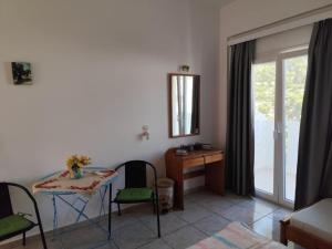 a living room with a table and chairs and a mirror at Vangelis rooms in Pitsidia
