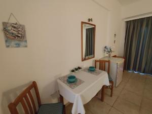 a room with a table and chairs and a mirror at Vangelis rooms in Pitsidia +10 photos