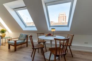 a room with a table and chairs and two windows at Jotica Colonia in Cologne
