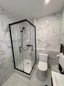 a white bathroom with a shower and a toilet at Le Thuillat Limoges in Limoges +28 photos