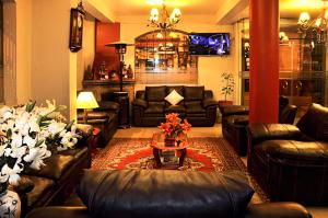 sala de estar con sofás de cuero y mesa en Casona Plaza Hotel Puno, en Puno