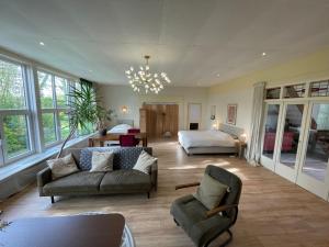 a living room with a couch and a bed at t Schooltje in Schoondijke