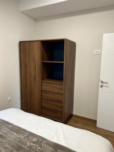 a large wooden cabinet in a room with a bed at Apartman Lea in Sibinj +7 photos