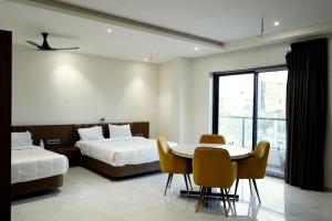 a hotel room with two beds and a table and chairs at Hotel Leena Inn in Jhālāwār +23 photos