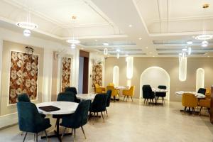 a restaurant with tables and chairs in a room at Hotel Leena Inn in Jhālāwār