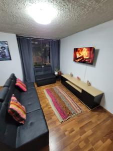 a living room with a black couch and a fireplace at Llama House Cusco in Cusco