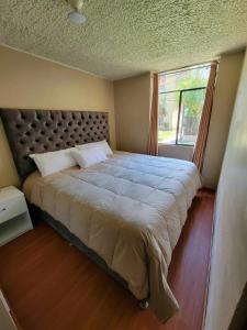 a bedroom with a large bed with a window at Llama House Cusco in Cusco