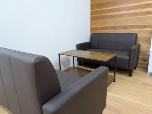 a waiting room with a couch and a table at hostel 丹鶴 in Shingū