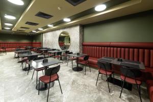 a dining room with tables and red booths at NOBO - Hotel in old Tbilisi in Tbilisi City