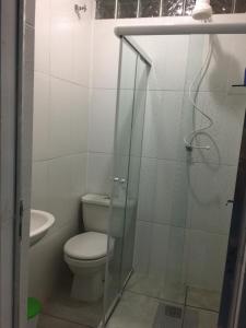 a bathroom with a toilet and a glass shower at Casa Praia Boracéia Bertioga in Boracéia +5 photos