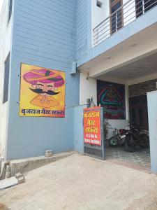 a building with two posters on the side of it at बृजराज गेस्ट हाउस & rooms in Rīngas