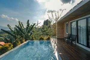 a swimming pool on a deck with a house at Olympus khaoyai in Ban Nong Makha