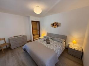 a bedroom with a bed and a table and a chair at La Rotonda apartments by Gardadomusmea in Tremosine Sul Garda