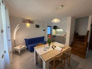 a living room with a table and a blue couch at La Rotonda apartments by Gardadomusmea in Tremosine Sul Garda