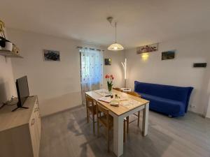 a living room with a table and a blue couch at La Rotonda apartments by Gardadomusmea in Tremosine Sul Garda